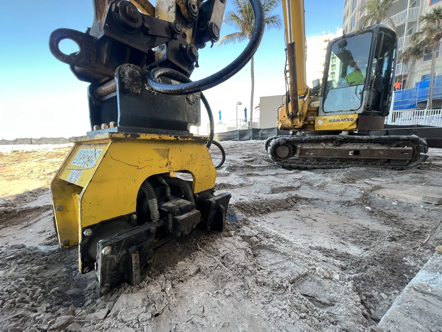Excavator attachment and tracked equipment staged on a jobsite